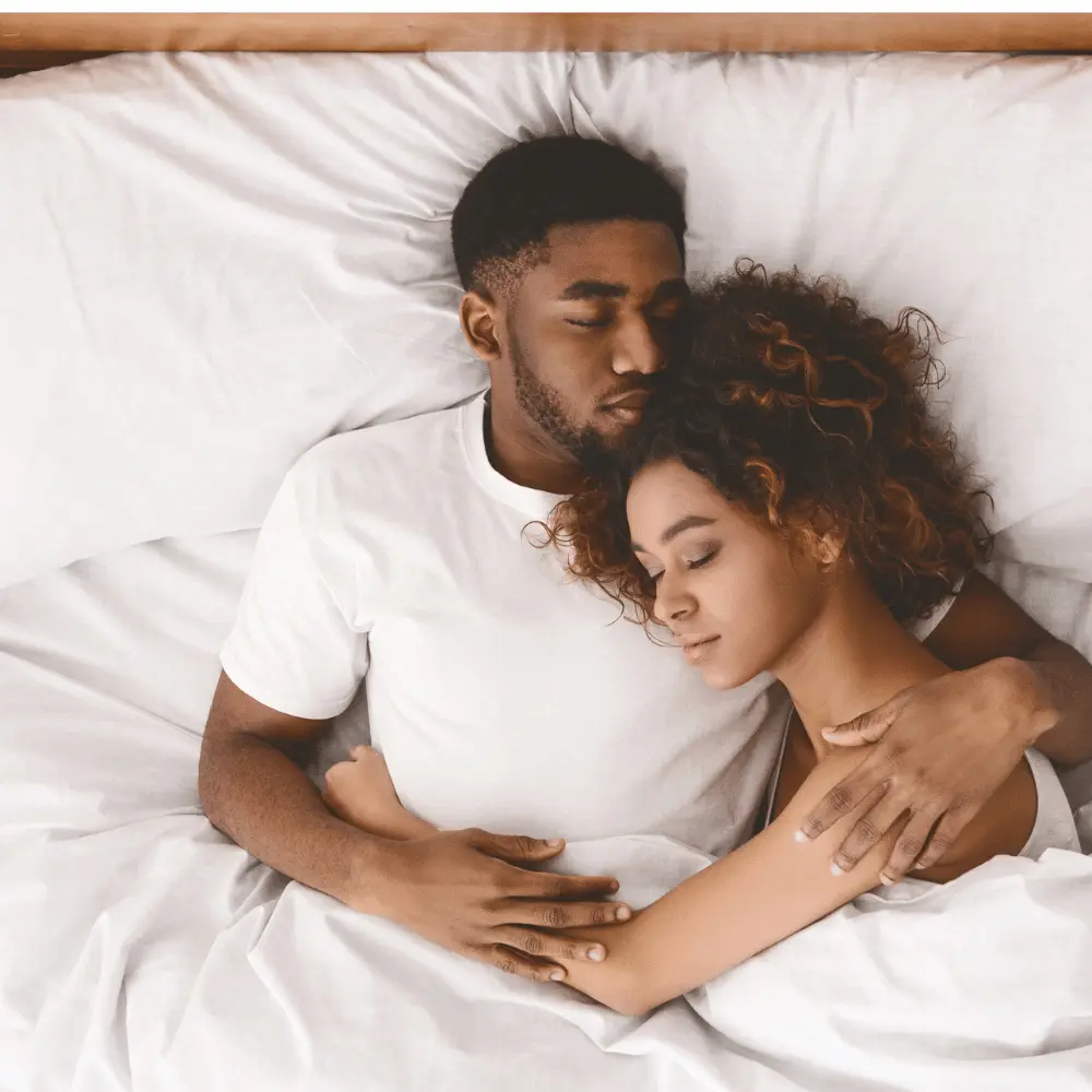 Couple cuddling peacefully while sleeping