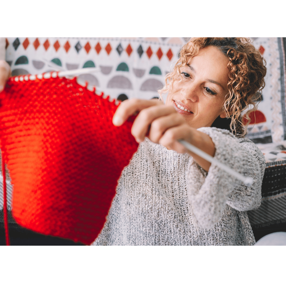 Woman crocheting red yarn