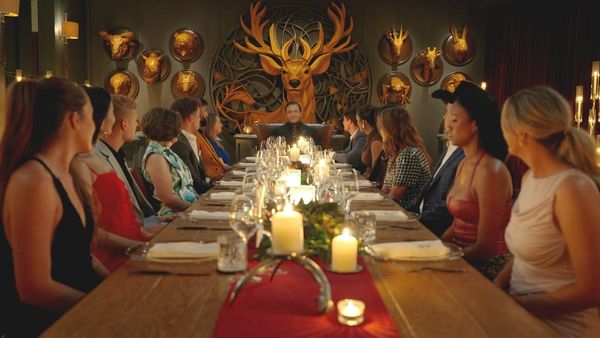 The Million Dollar Secret season 2 cast sits at dinner with host Peter Serafinowicz. (Photo Credit: Courtesy of Netflix.)
