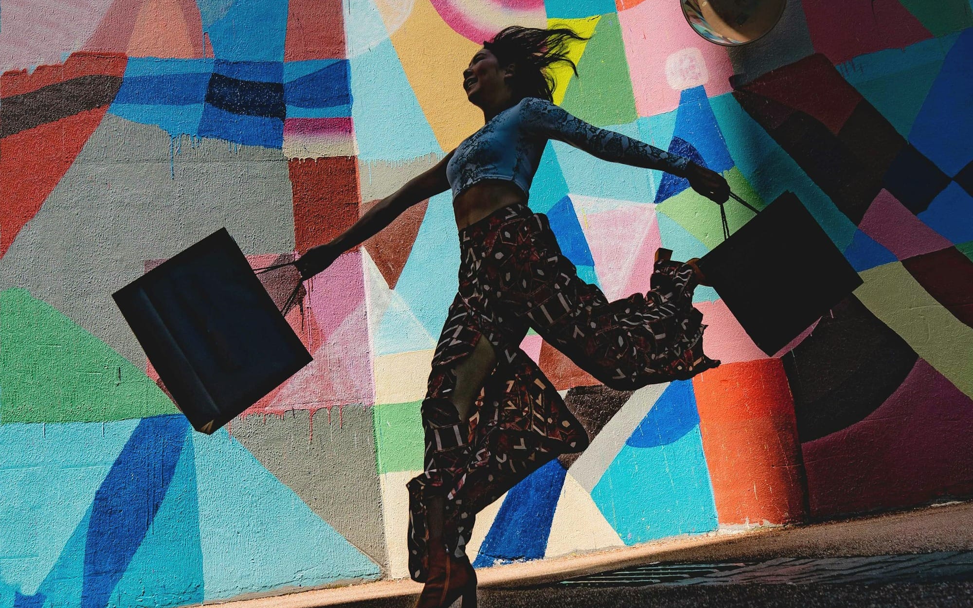 woman holding bag beside mural painting