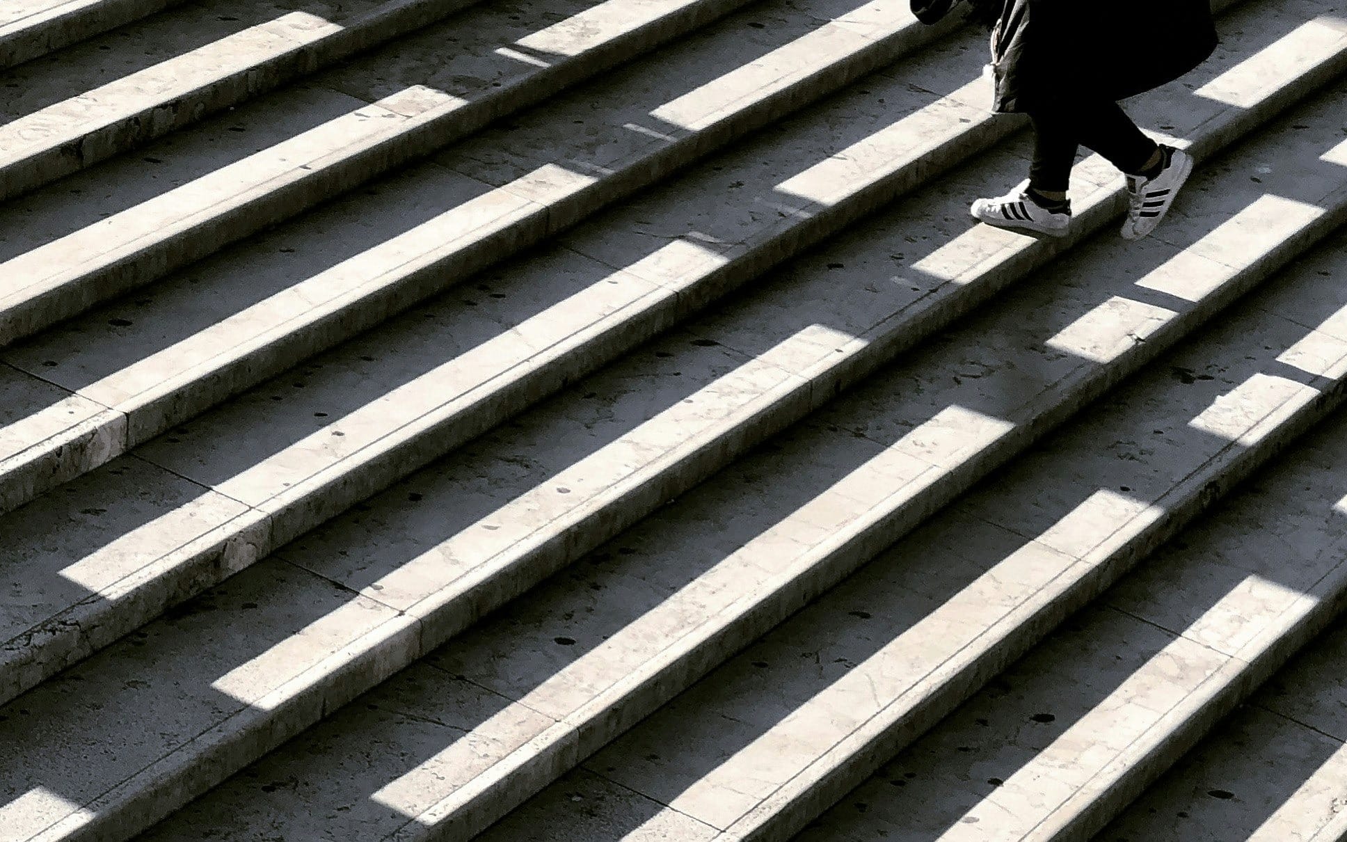 person wearing black jacket walking on stair photography
