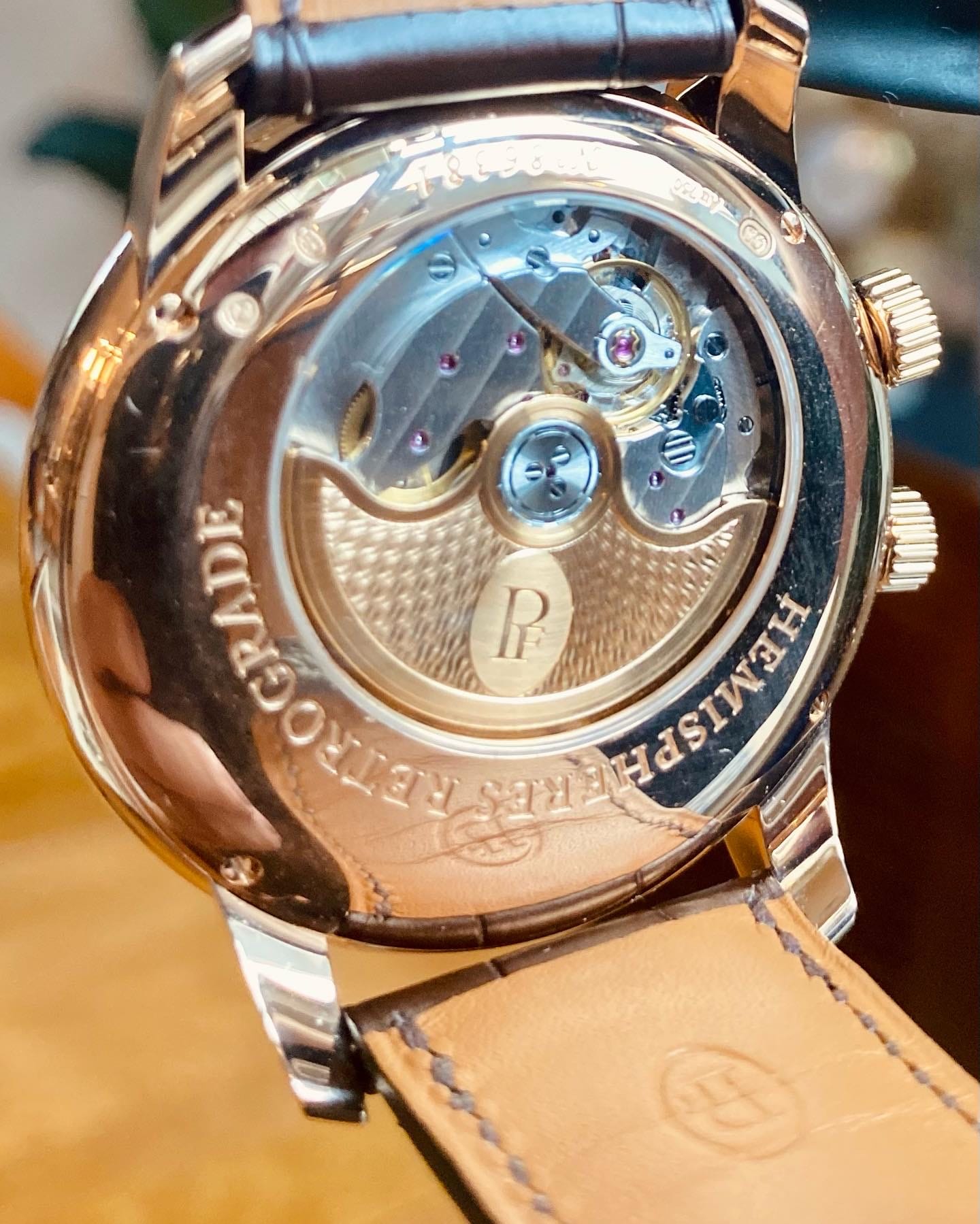 Close view through the sapphire caseback of the decorated automatic movement and Hermès leather strap on a rose-gold Parmigiani Fleurier Toric.