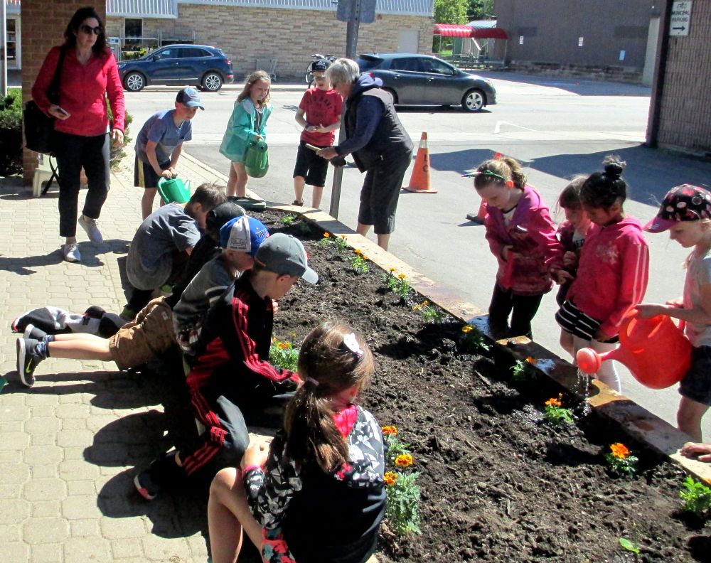 Arthur Public School students helped plant flowerbeds at Arthur Post Office post image