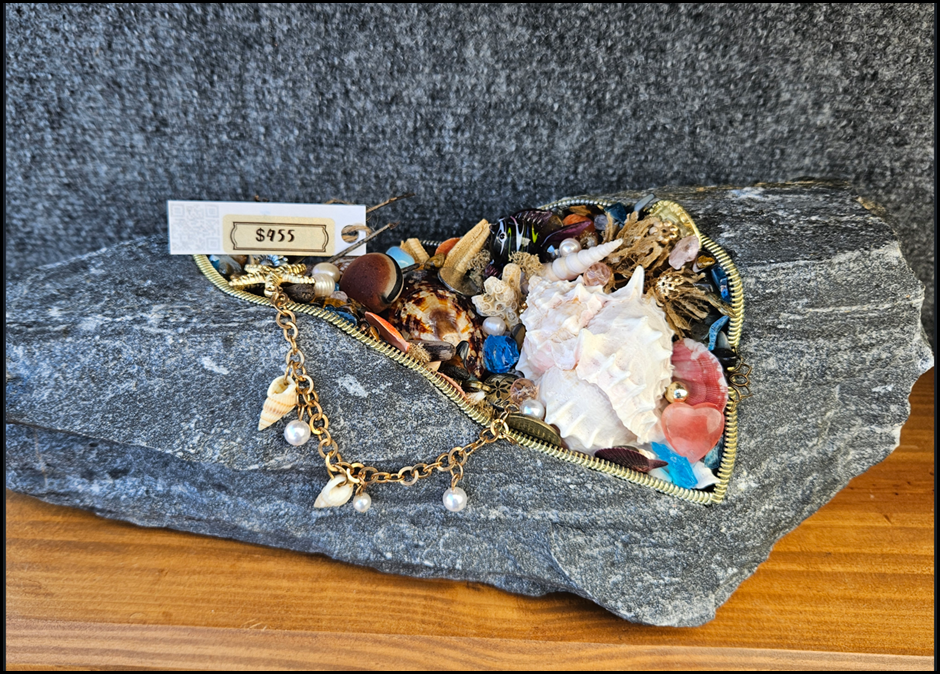 A heart shaped necklace with shells and pearls

AI-generated content may be incorrect.