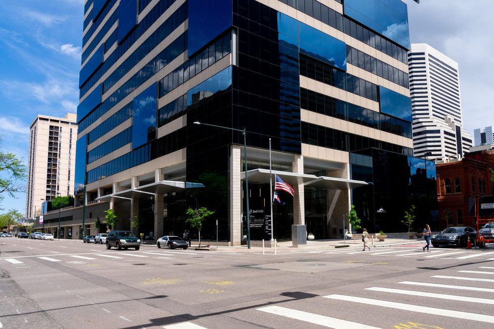 Mid-rise glass office building at a downtown Denver street corner