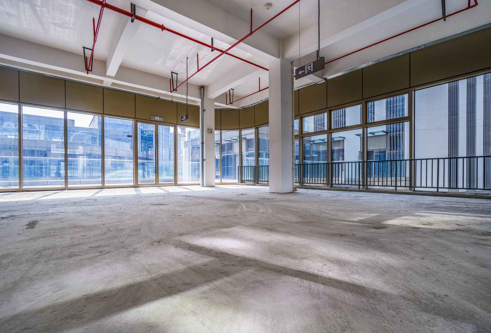 Vacant unfinished office floor with a bare concrete slab and floor-to-ceiling windows