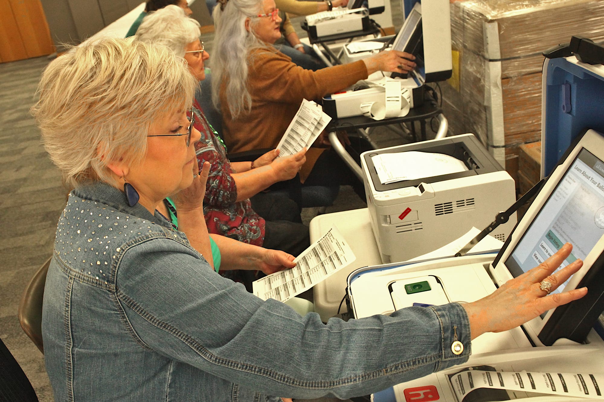 woman sitting at touch writer screen keying in test ballots