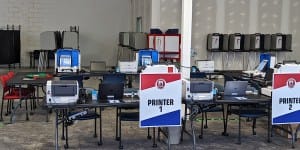 printers with signs that say "Printer 1" etc. inside voter operations center