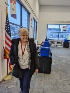 woman standing next to American flag inside a voting operations center