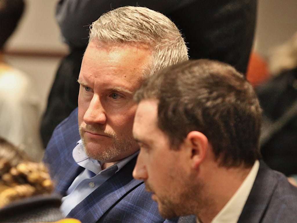 two men seated conferring with each other