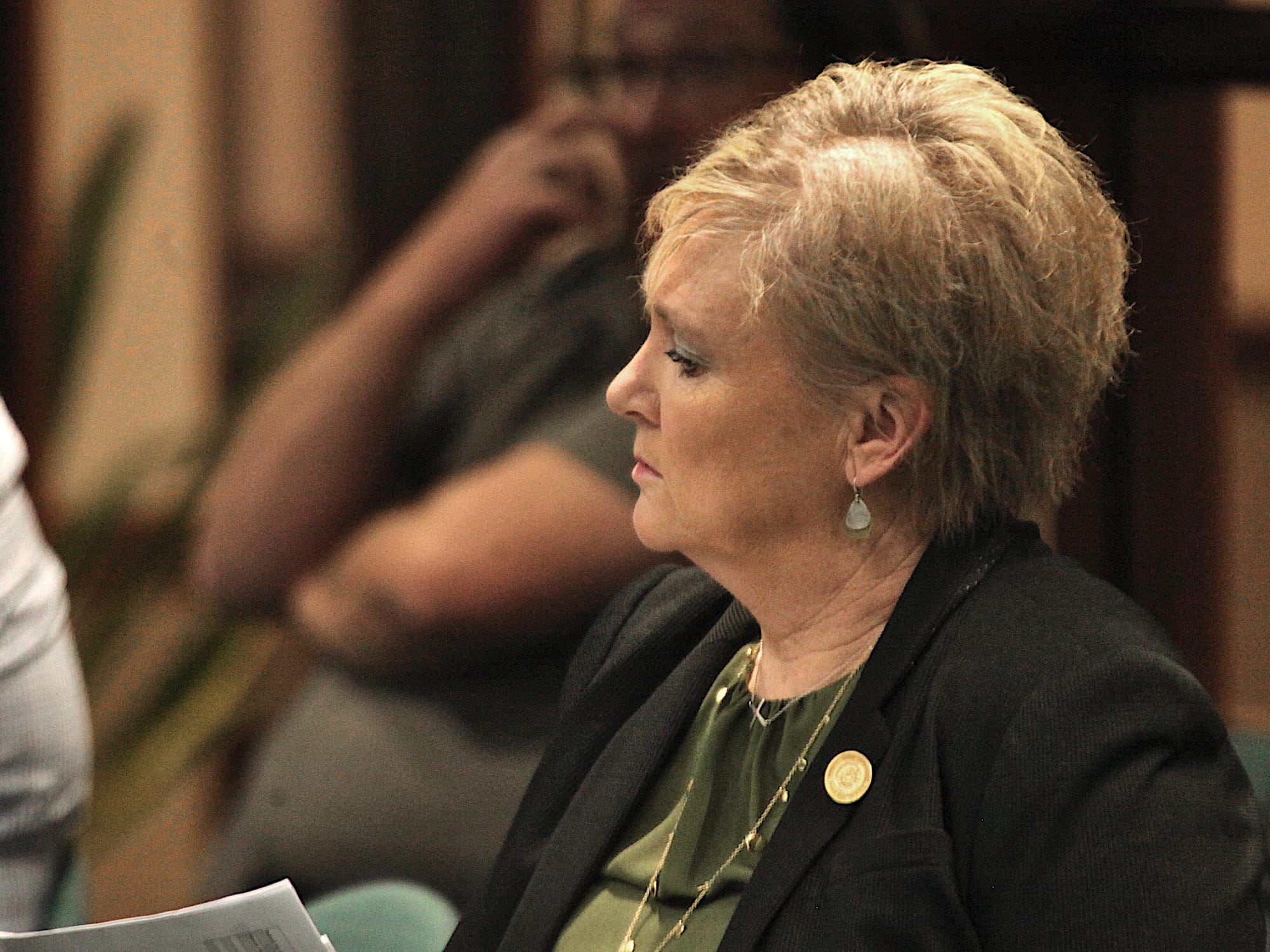 woman seated in a chair in audience at council chambers