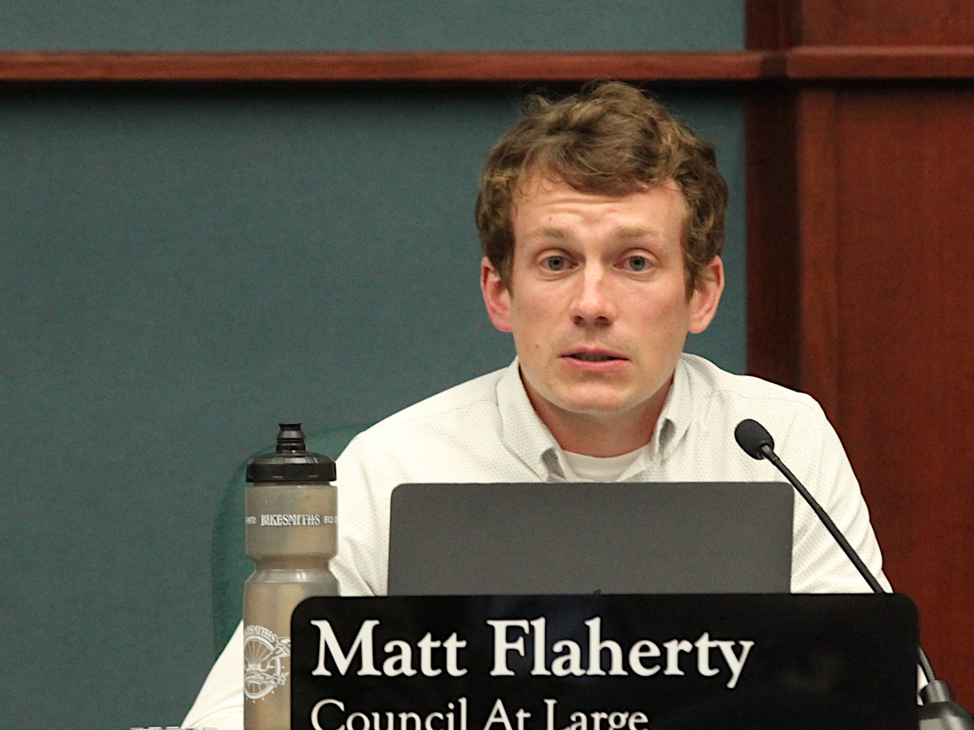 man seated at city council dais