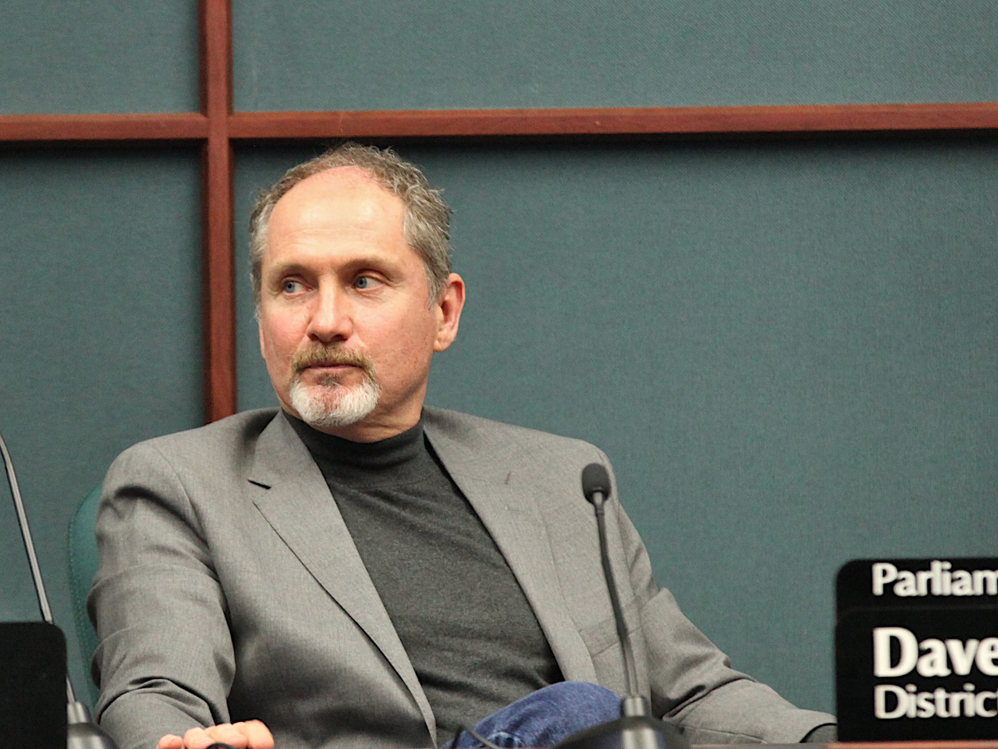 man seated at city council dais