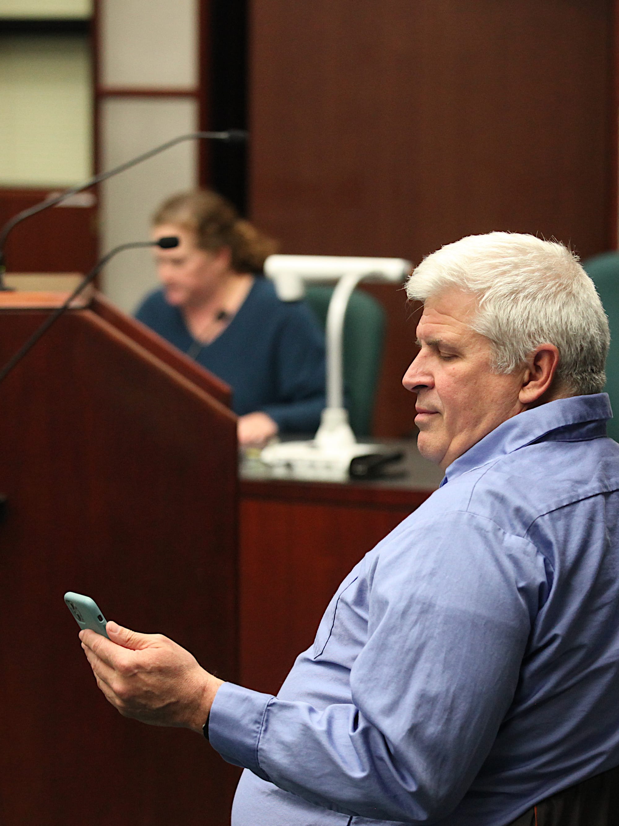 man sitting in chair looking at smartphone