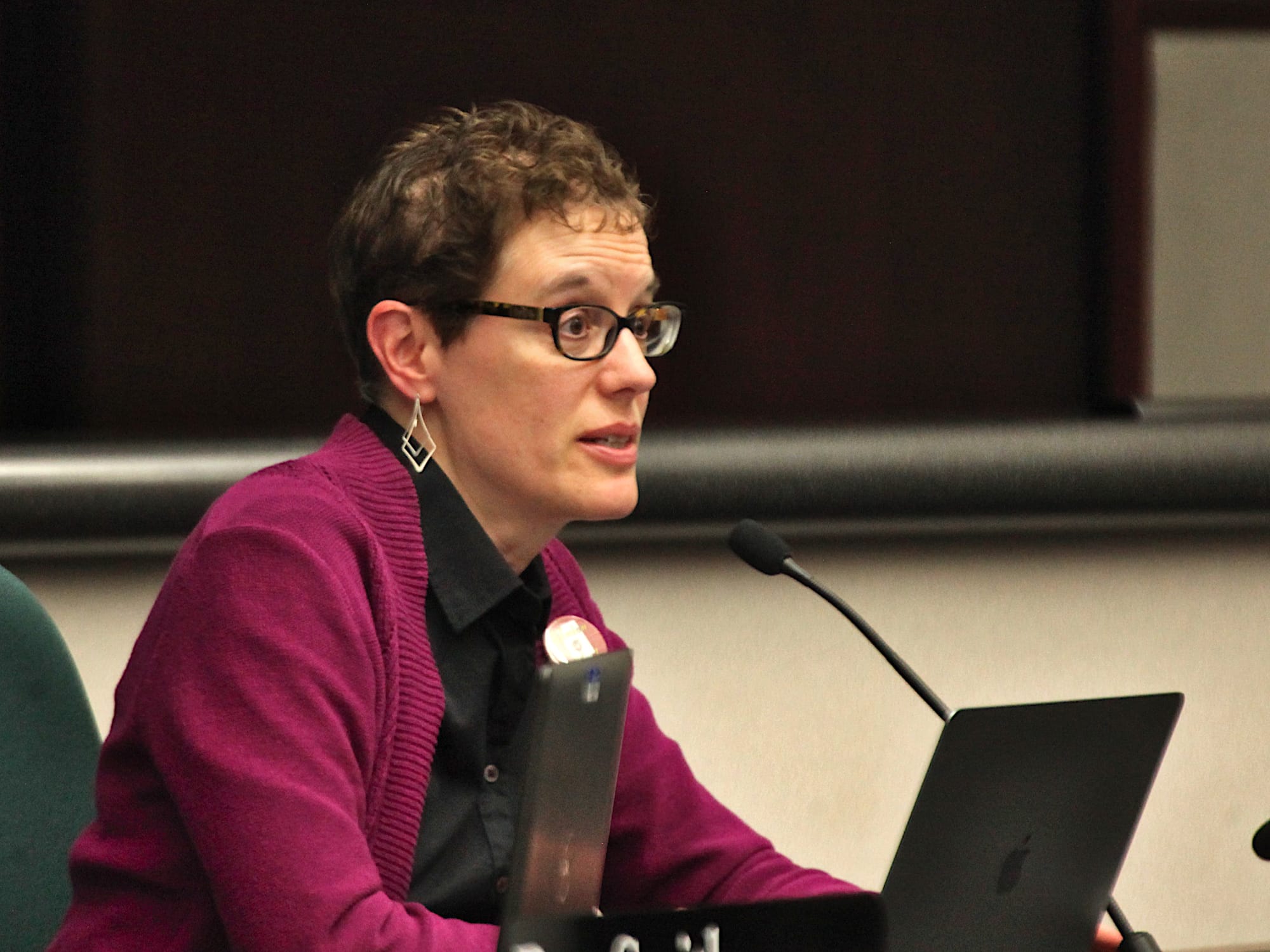 woman seated at city council dais