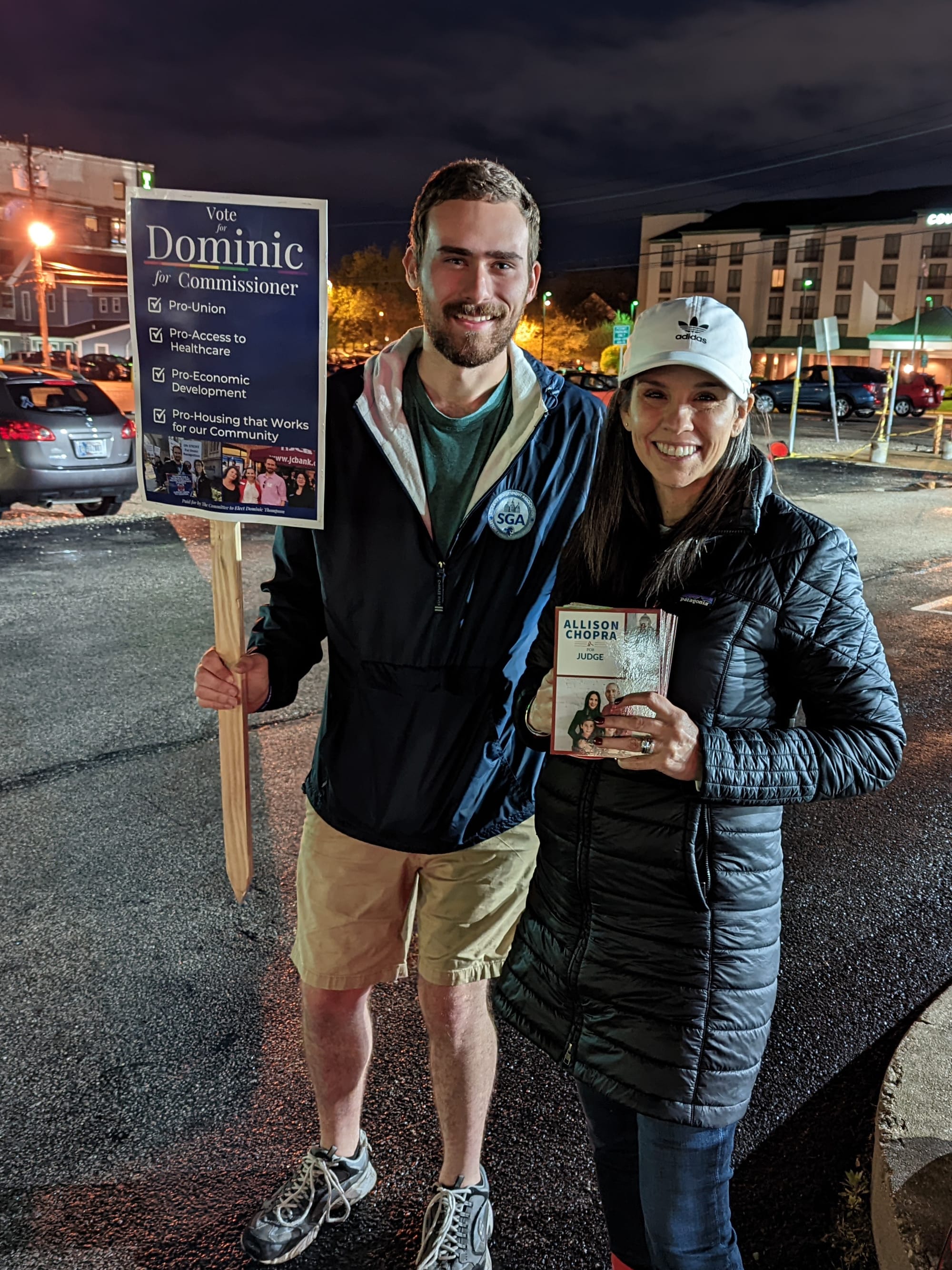 two people standing side by side holding campaign materials