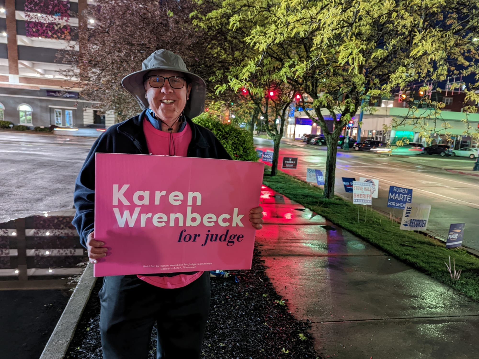 man holding a campaign sign that says Karen Wrenbeck