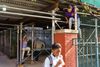 Children climb on the scaffolding outside of their school building