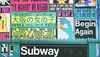 An image of a subway entrance with colourful graffiti style posters behind it on the wall