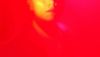 A face obscured by bright pink light