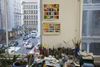 A desk covered in art supplies in front of a window looking out onto a Manhattan street