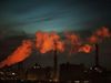 Orange smoke floats across the New York City skyline at dusk