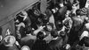 A black and white old photo of commuters entering a train