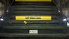 Dark subway stairs with yellow sign that reads "SAY SOMETHING"