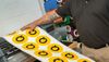 Man holds open a large printing page of the subway logo Q