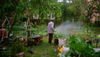 A man waters his lush backyard garden in Brooklyn