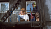 Three young adults gather on a fire escape
