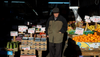 A man stands in the midst of a produce display at a grocery store