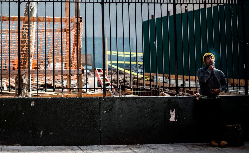 A construction worker smokes a cigarette on his break