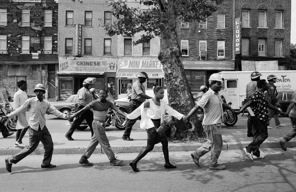 A line of protestors linking hands during the 1991 Crown Heights riot