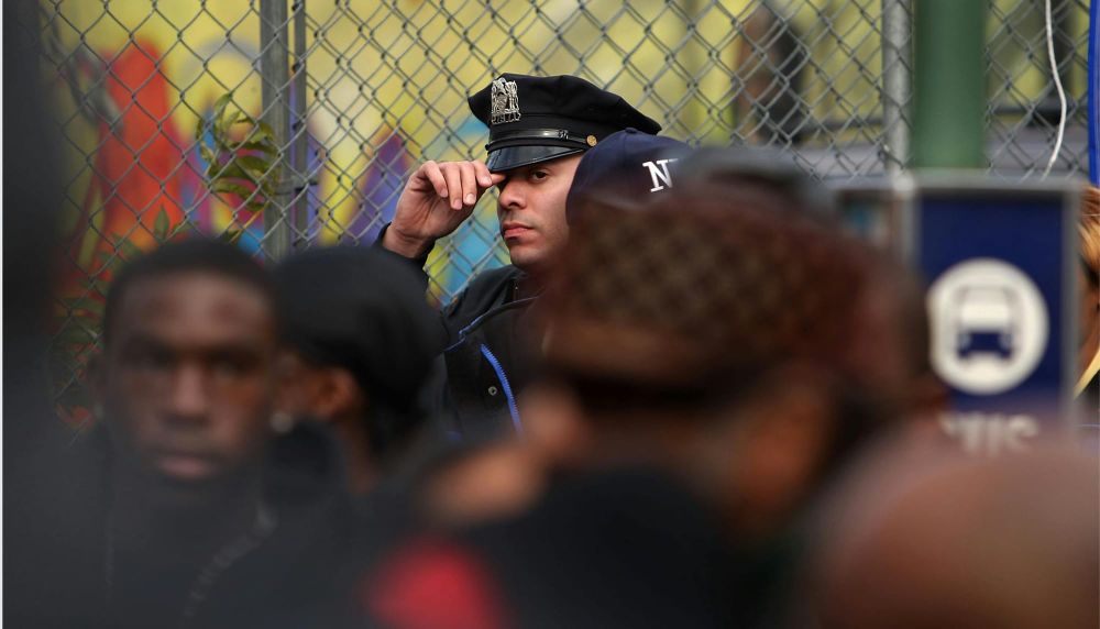 NYPD police officer touches his hat in a crowd 