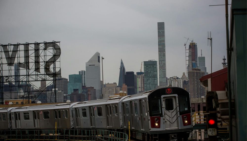 Subway train approaching with Manhattan skyline in the background