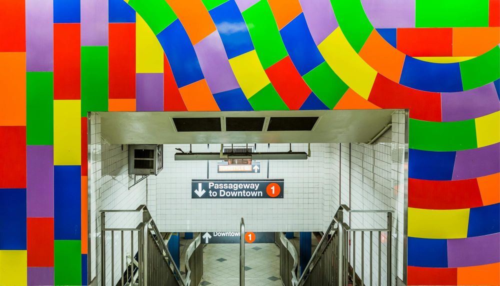 The subway entry to the 1 with colourful wallpaper around it