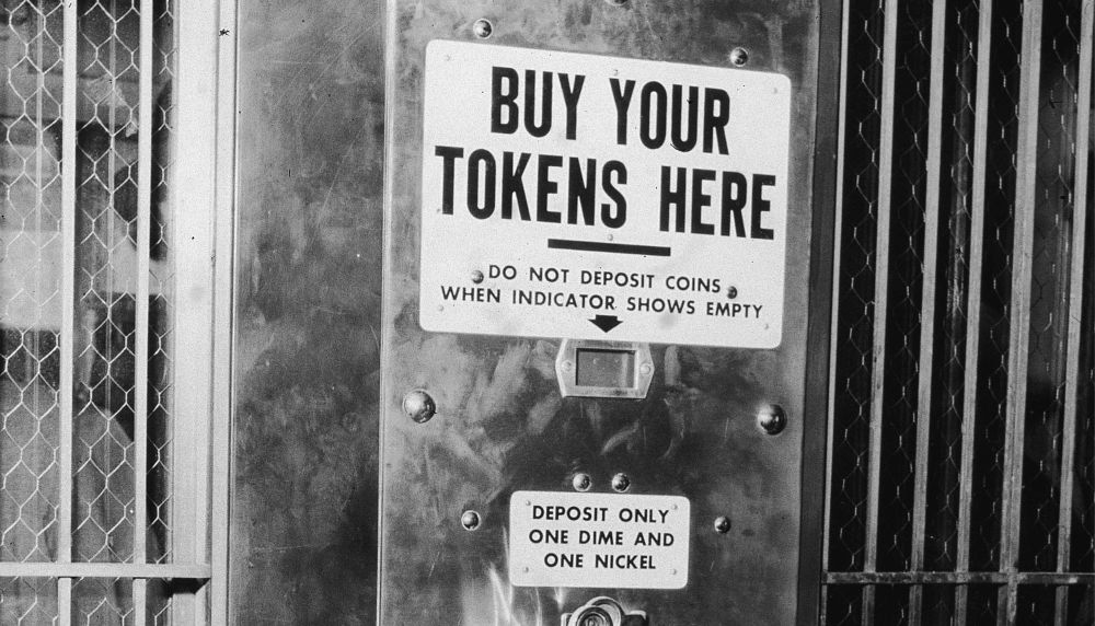 Black and white photo of a subway token machine