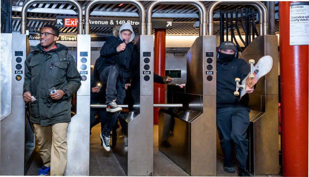 Three men enter subway turnstiles, one jumping over the barrier