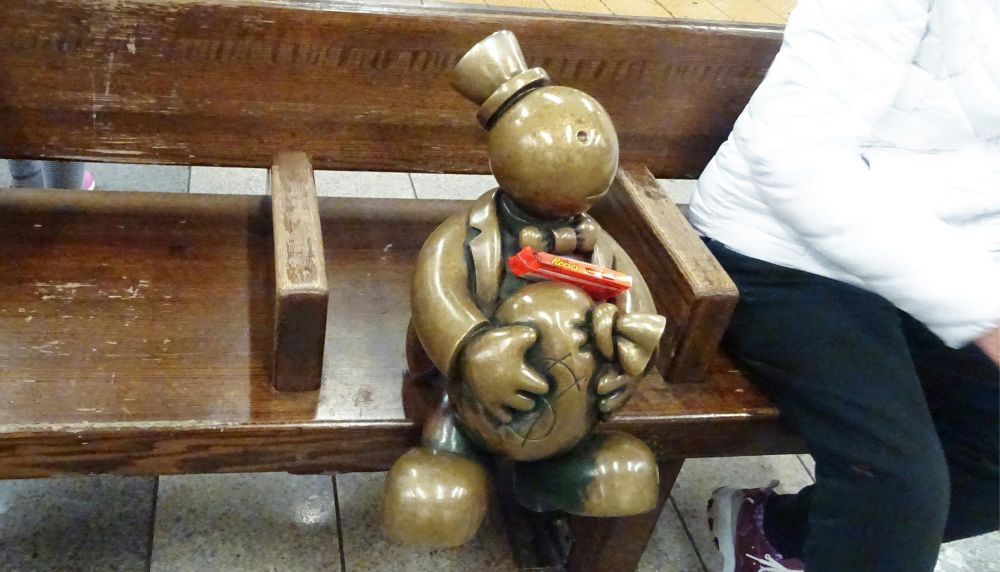 Toy person sits on a subway bench
