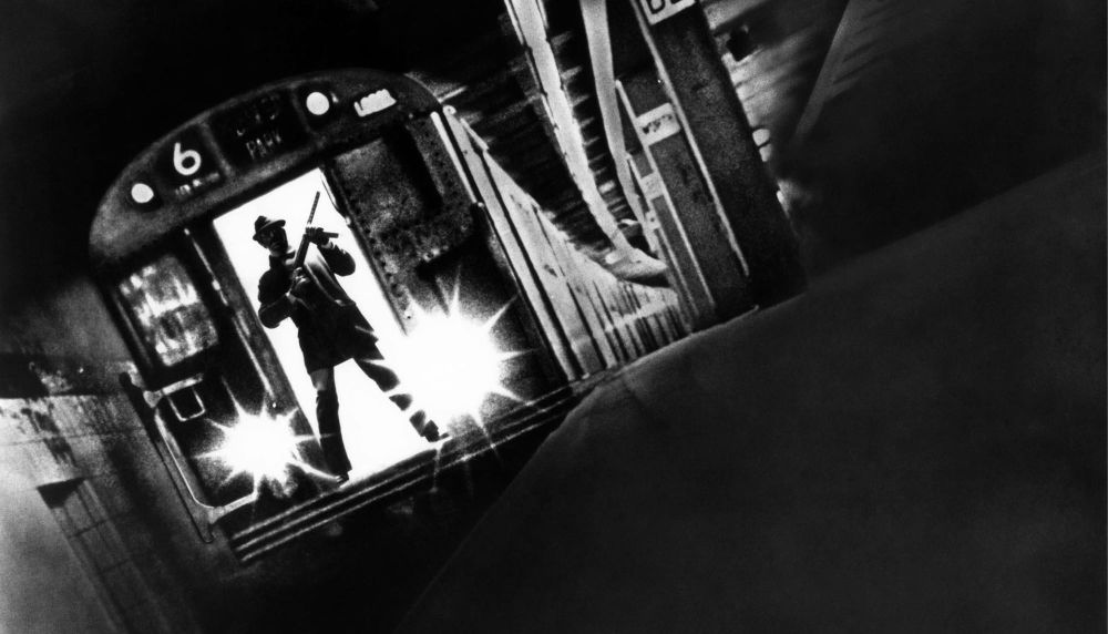 Still from Pelham film of man standing with gun at the front of a subway car