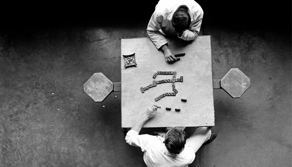 Two inmates play a game of checkers at a table