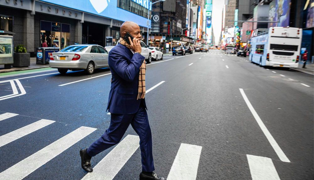 New York City Mayor Eric Adams walks to the subway in midtown Manhattan on his phone, on his second day in office in 2022.