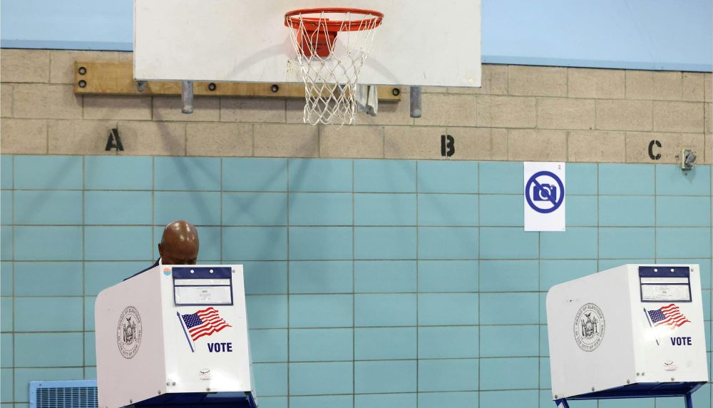 Democratic candidate for New York City Mayor Eric Adams fills his ballot in a privacy booth while voting.