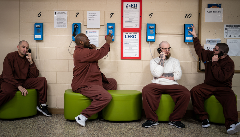 Inmates in the Little Scandinavia unit in Chester Correctional Institution it on green stools and make calls on the unit's phones