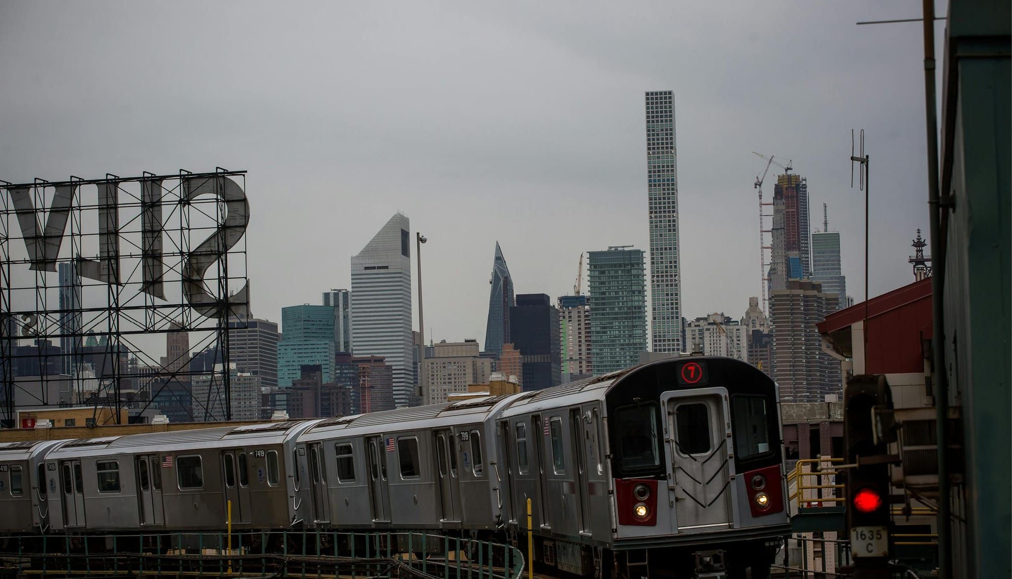 Subway train approaching with Manhattan skyline in the background