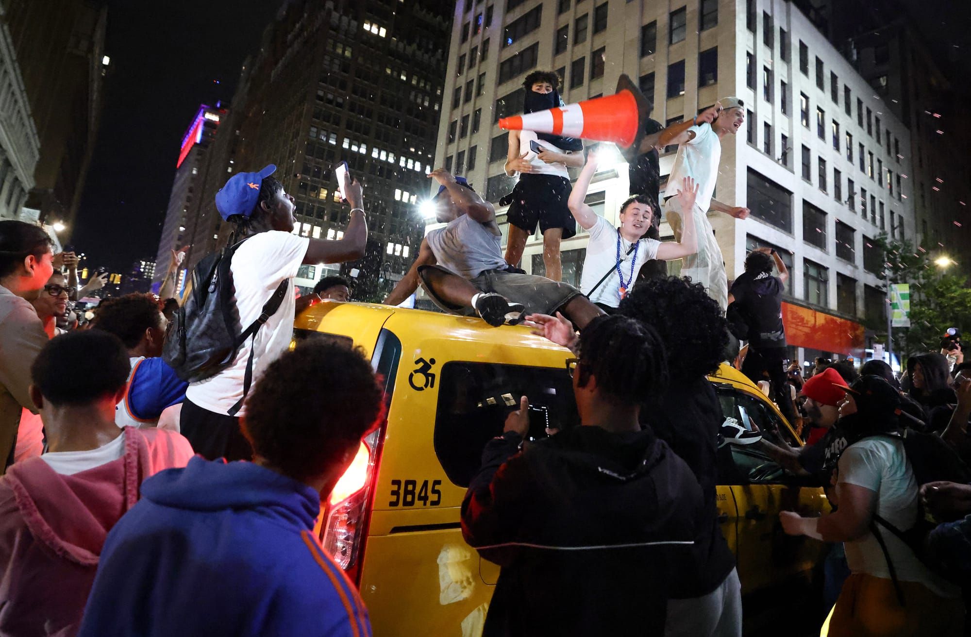 Rowdy Knicks fans atop a taxi cab.