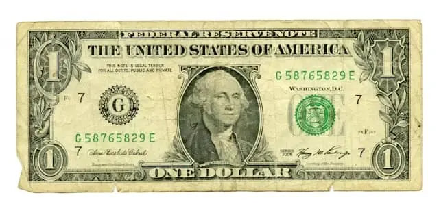 A worn U.S. one-dollar bill symbolizing the fiat currency backing that ensures stablecoins maintain a stable value.