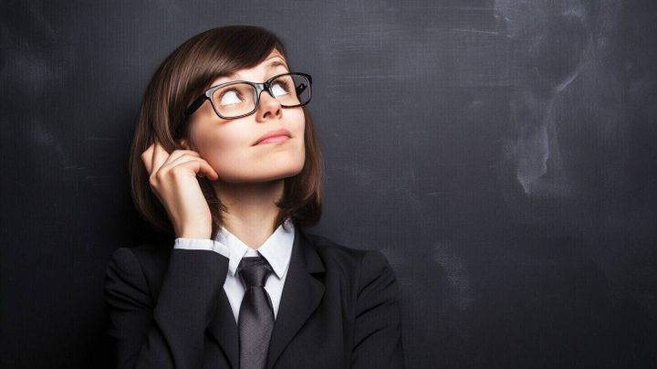 Image of a female accountant looking upwards towards the future with a blackboard as a background