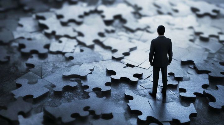 Image of an accountant standing on a set of puzzle pieces